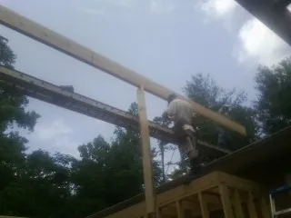 Carpenter setting a ridge beam over a new addition frame — Ice Dam Removal by Roofing Brothers in Miramar Beach