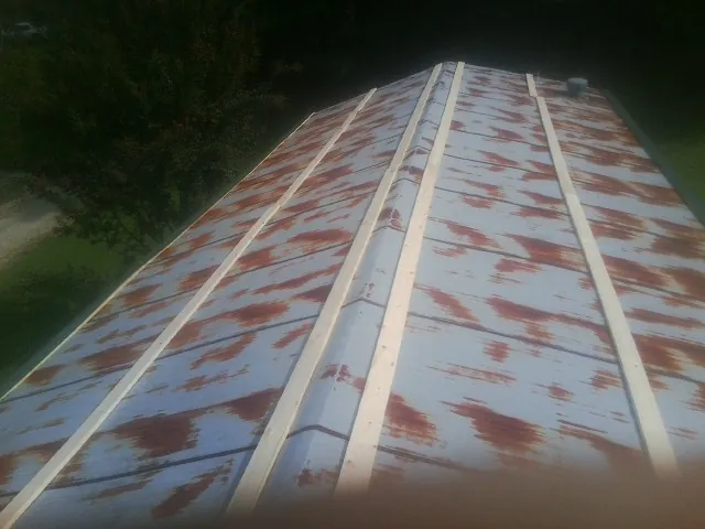 Rusted metal roof panels with new wood purlins before replacement — Storm Damage Roof Repair in Miramar Beach by Roofing Brothers