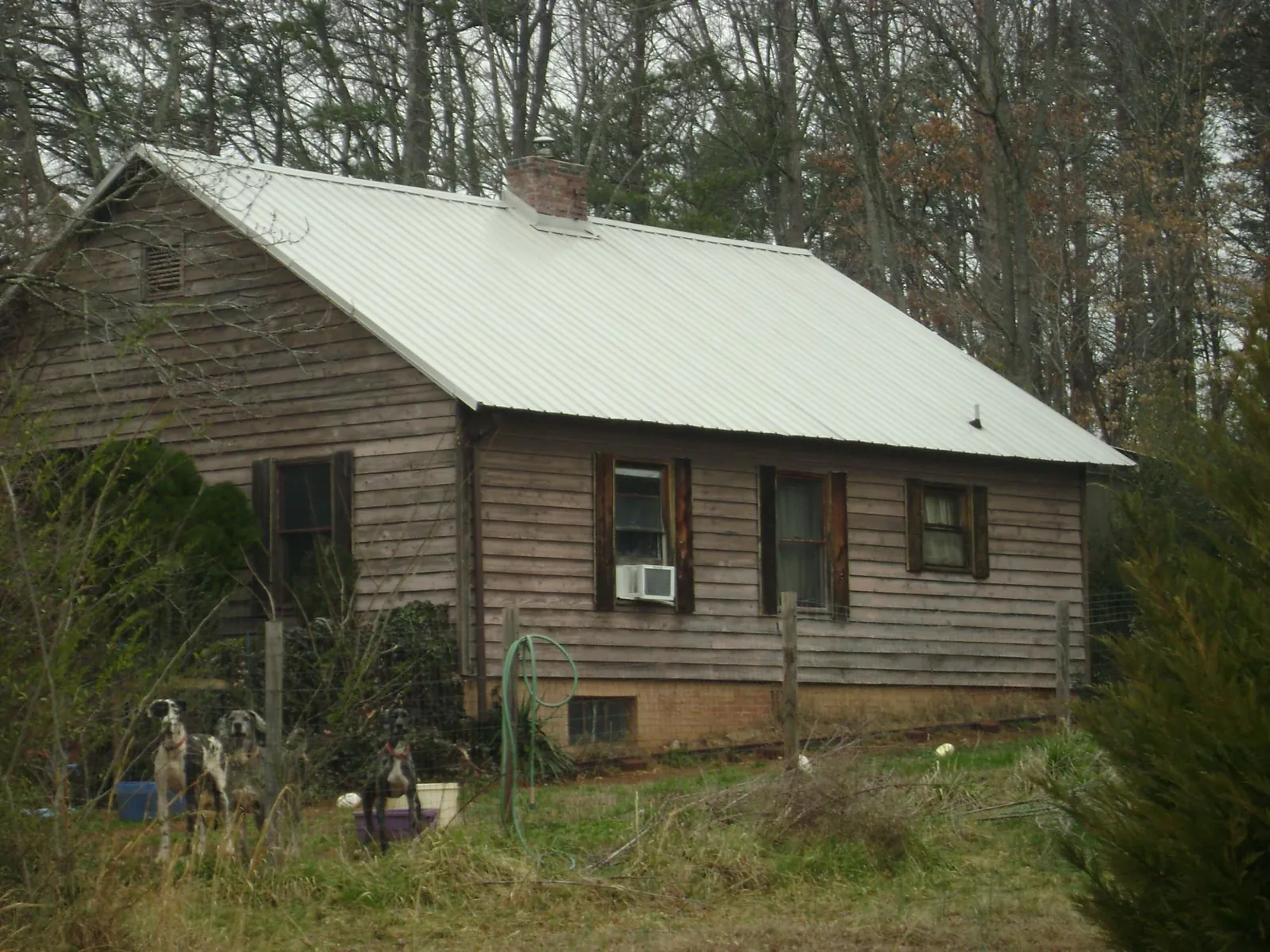 White metal roof on an old wood sided farmhouse, from a Metal Roof Installation job in Miramar Beach